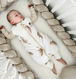 Baby schlafend im Babybett trägt Schlafsack mit Füßen mit Pampas Muster