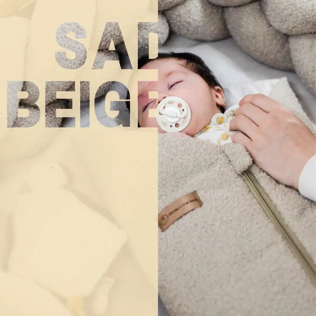 schlafendes Baby in einem beigefarbenen, flauschigen Schlafsack mit einem Schnuller.